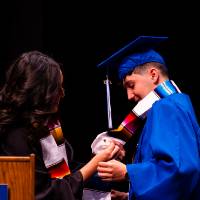 Antonio receiving monarch butterfly pin.